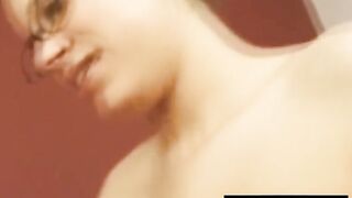 Big-titted brunette sucks on tiny cock in glasses